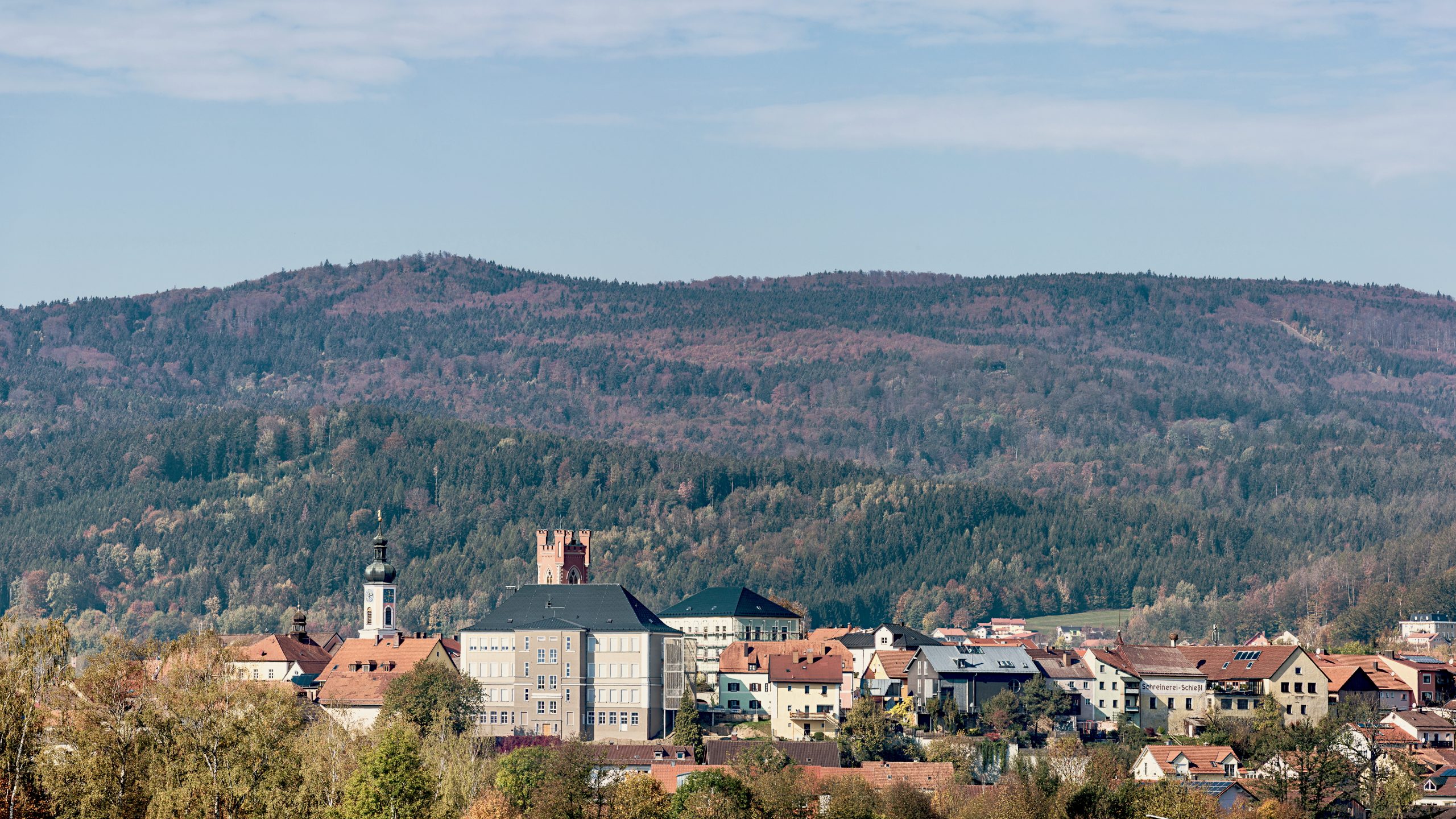 Blick auf den Stadtkern von Furth im Wald mit Stadt- und Kirchturm sowie der stadträumlich prägenden Fachakademie für Sozialpädagogik.