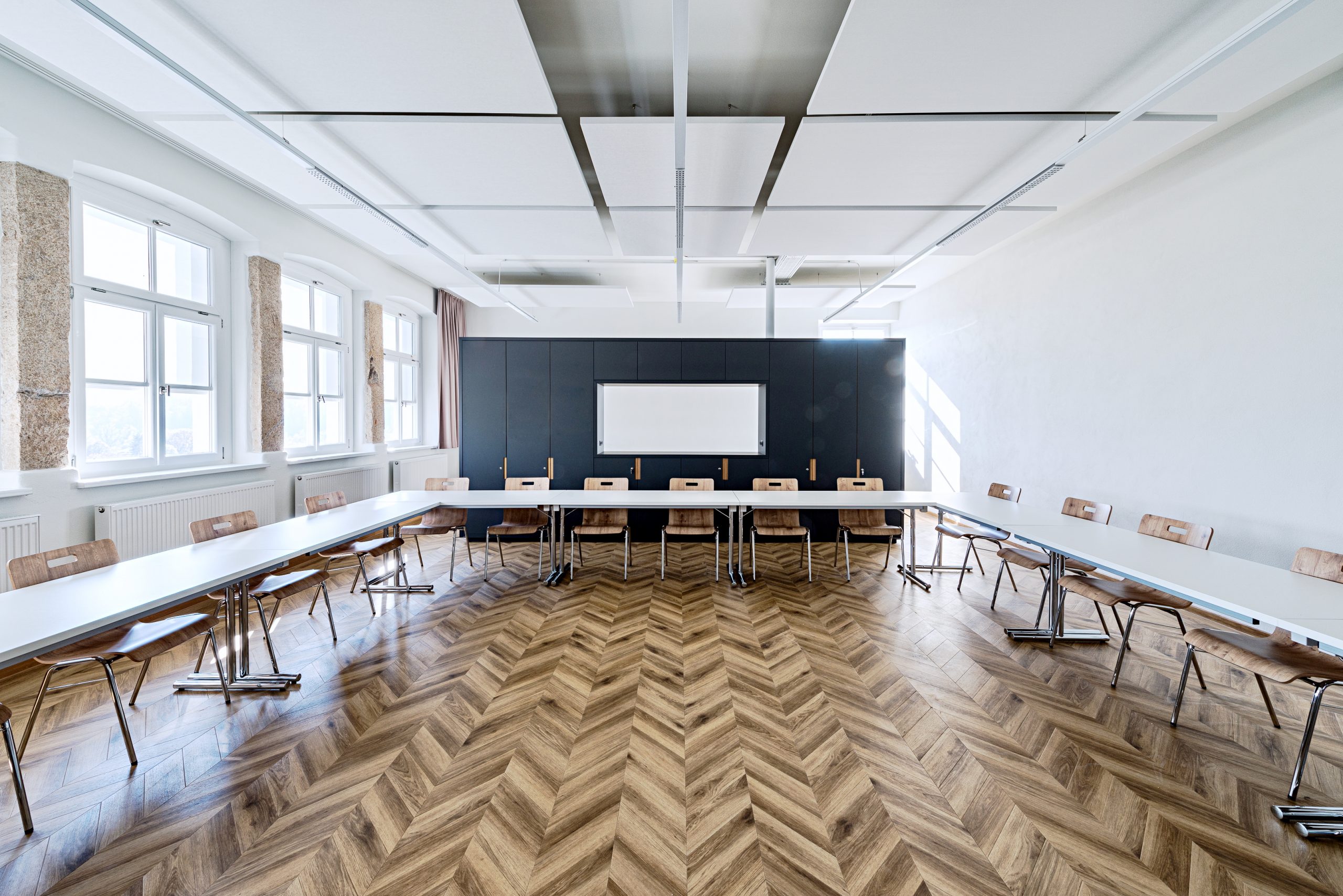 Klassenzimmer der Fachakademie für Sozialpädagogik Furth im Wald mit wiederhergestellter Raumordnung, Natursteinsäulen, Eichenholzboden und Akustiksegeln.