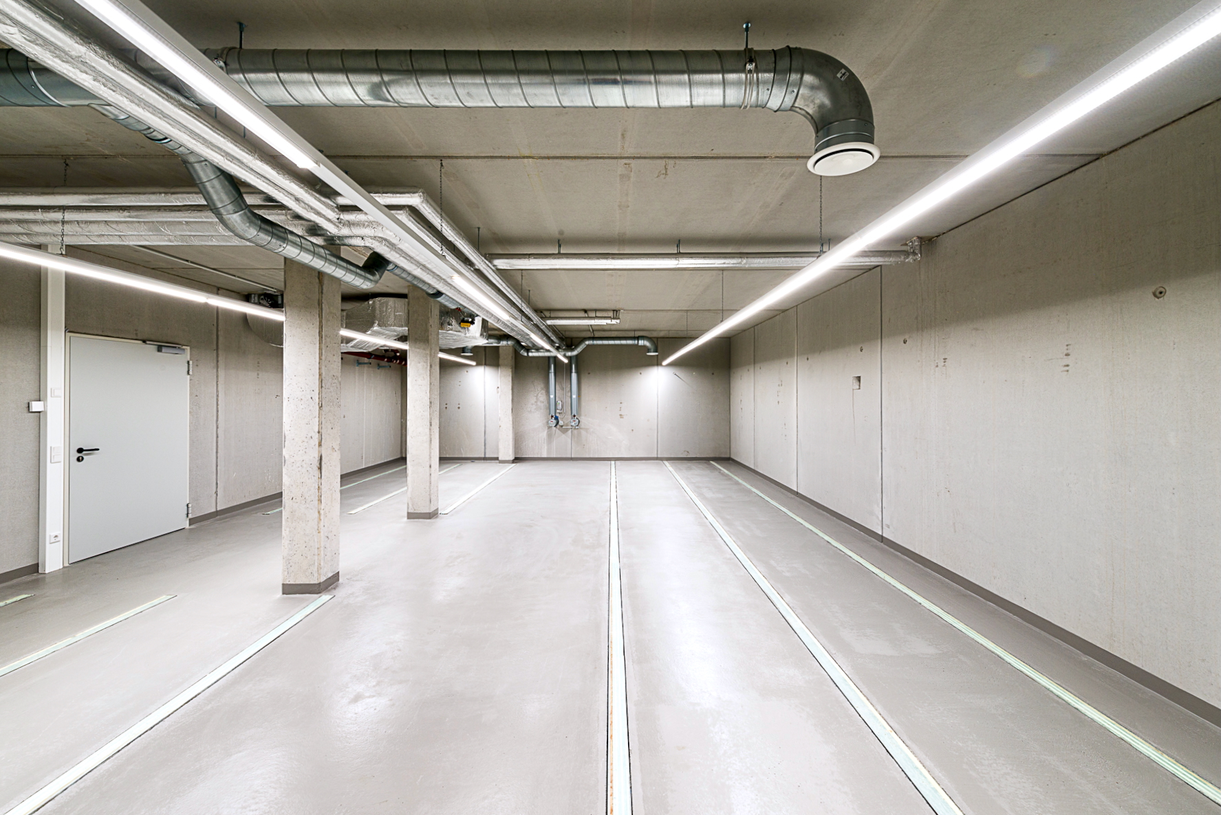 Archivraum im Kellergeschoss des Finanzamts Waldmünchen, Außenstelle des Finanzamts Erlangen, aus anderem Blickwinkel aufgenommen, ohne Rollregale und mit sichtbarer Installation im Deckenbereich.