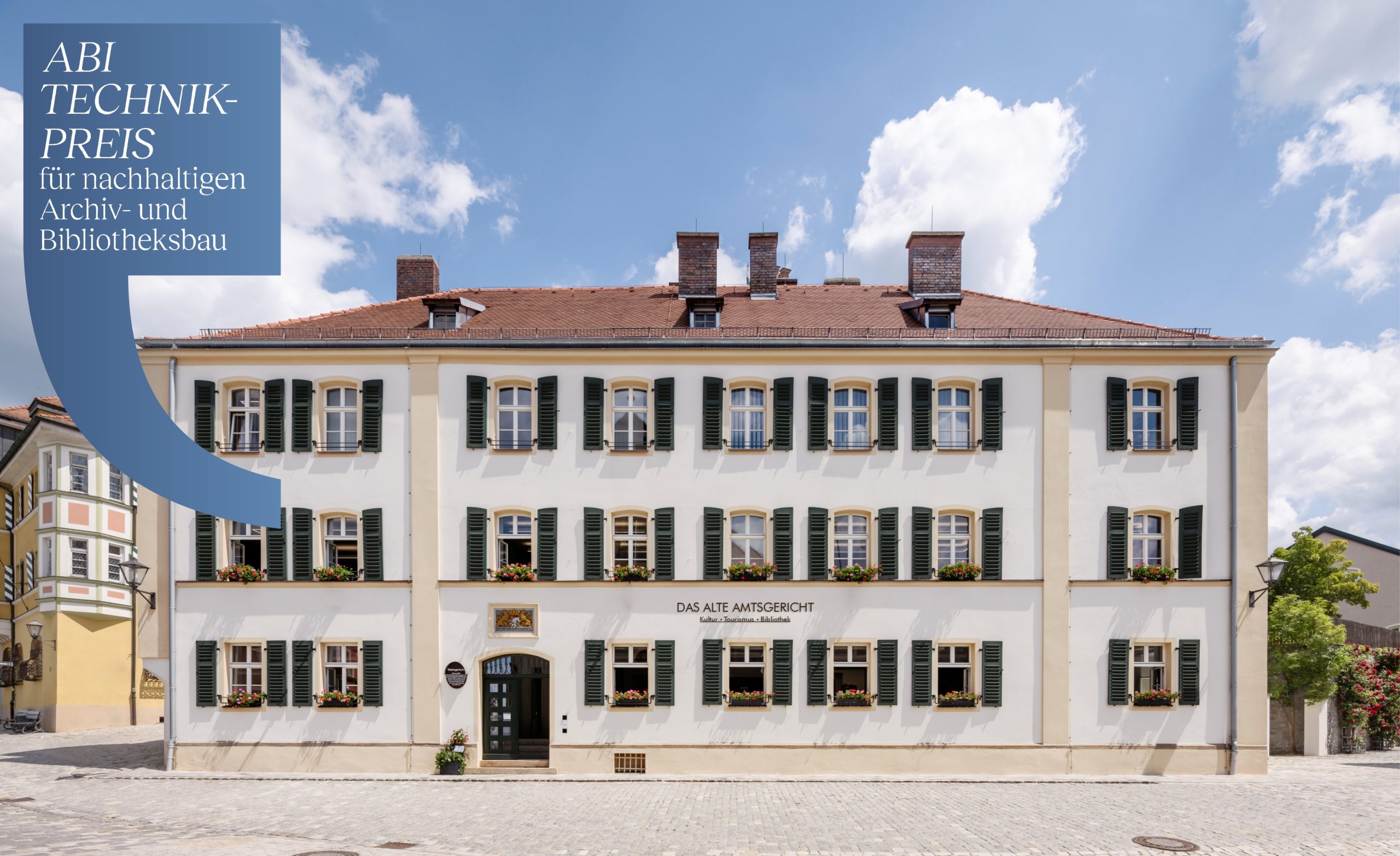 Außenansicht des denkmalgerecht sanierten Alten Amtsgerichts in Furth im Wald mit eingeblendetem abi Technik-Preis 2026 für nachhaltigen Archiv- und Bibliotheksbau.